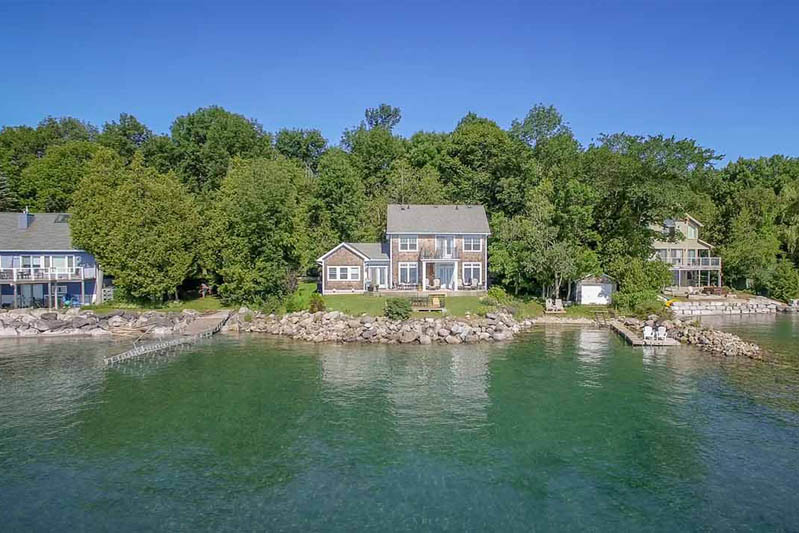 aerial view over water looking at a waterfront property for sale