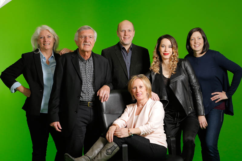 real estate team portrait on a green background in a studio setting