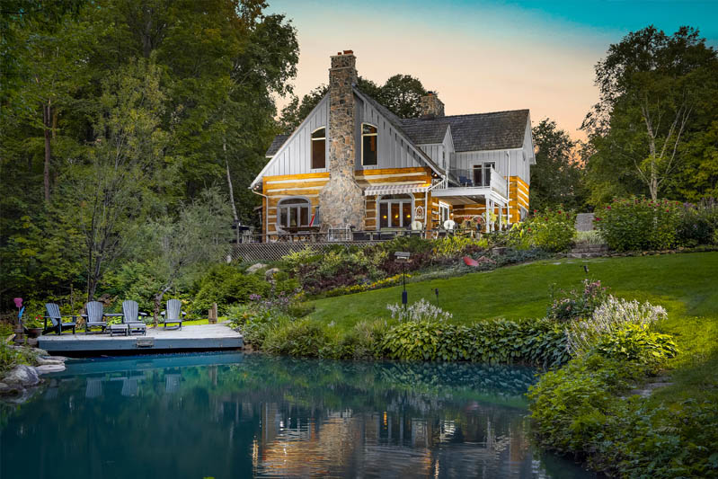 view of a house across a pond, lit up at night