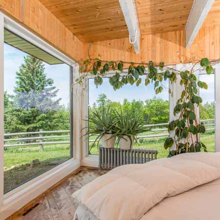 Beautiful bedroom with big windows to green scenery in real estate photography