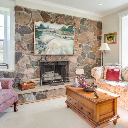 view of a bright living room with stone fire place