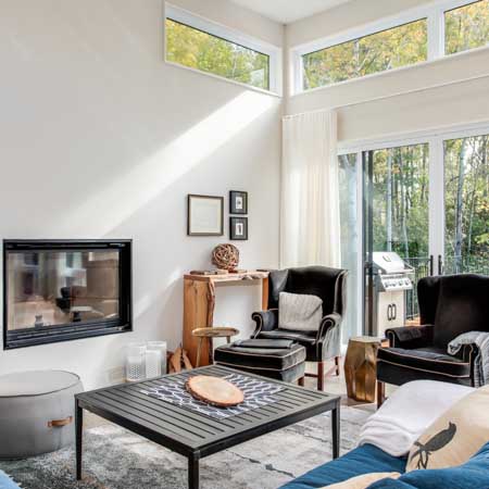 Natural light pouring into living room with double high ceilings and windows