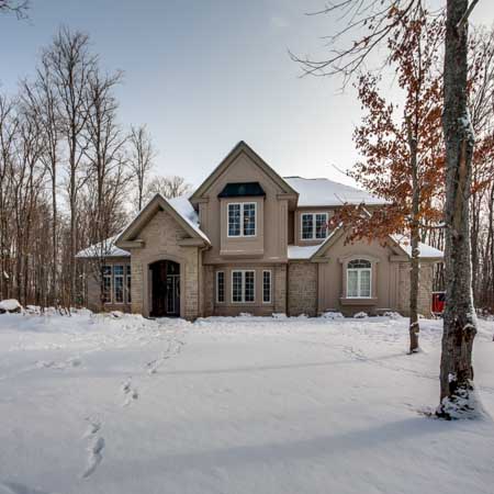 Winter view of a front elevation on a beautiful house in the woods