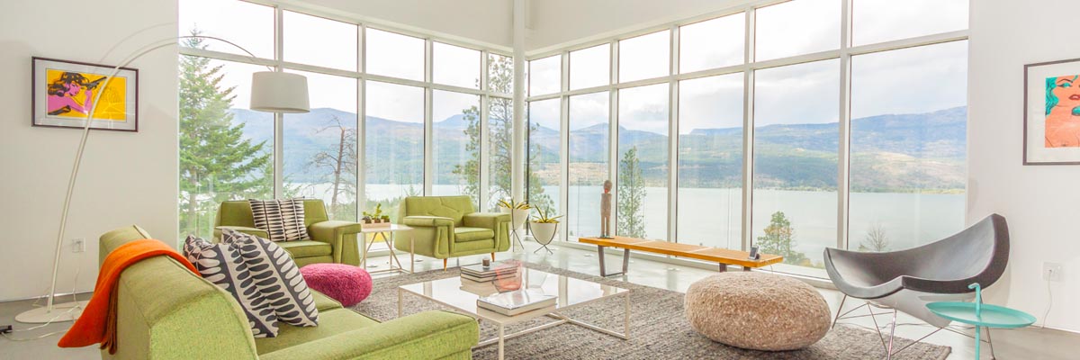 photo of a property with large glass walls overlooking mountain lake, real estate photography